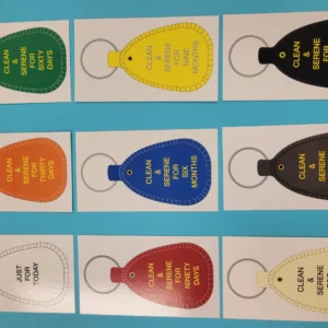 Colorful sobriety keychains on display board.