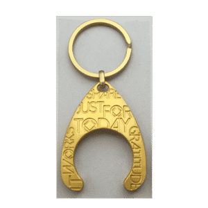 Gold-colored keychain with motivational words.